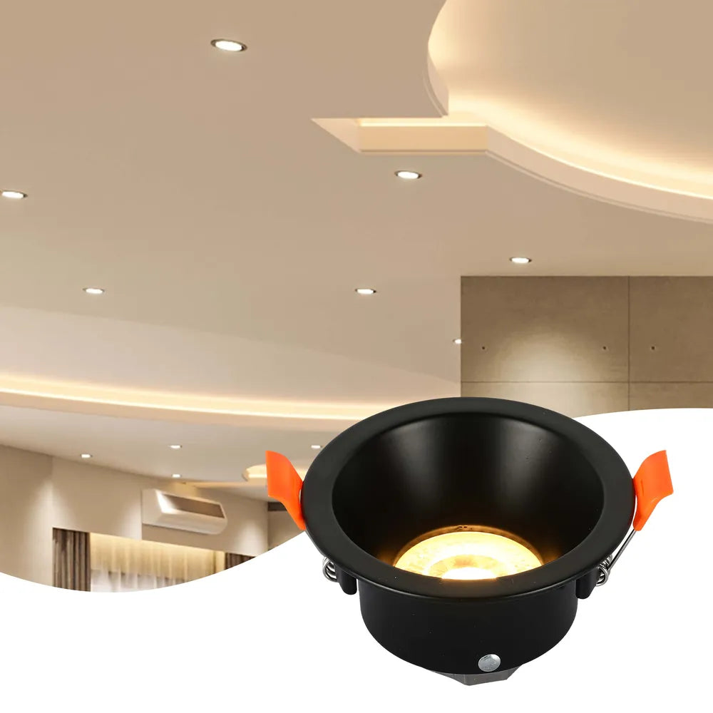 Sleek GU10 downlight fixture illuminates a modern living room with stylish décor, providing a warm ambiance in a cozy setting.143-03996